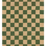 Detail of the Checkerboard Rug in Pawn, a green and tan checkered pattern. 