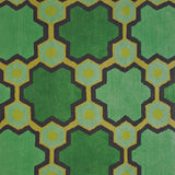 Detail of the Cordoba Cut Pile Rug in Emerald, a hexagonal lattice pattern with sahdes of emerald, jade, yelow and chcolate brown. 