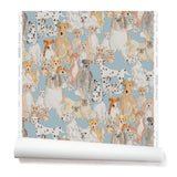 Partially unrolled wallpaper with a pattern of many different types of illustrated watercolor dogs. Background is light blue.
