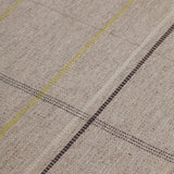 Detail of the Jasper Waffle Rug in Peridot, a large scale plaid pattern of ecru, yellow, grey and off white. 