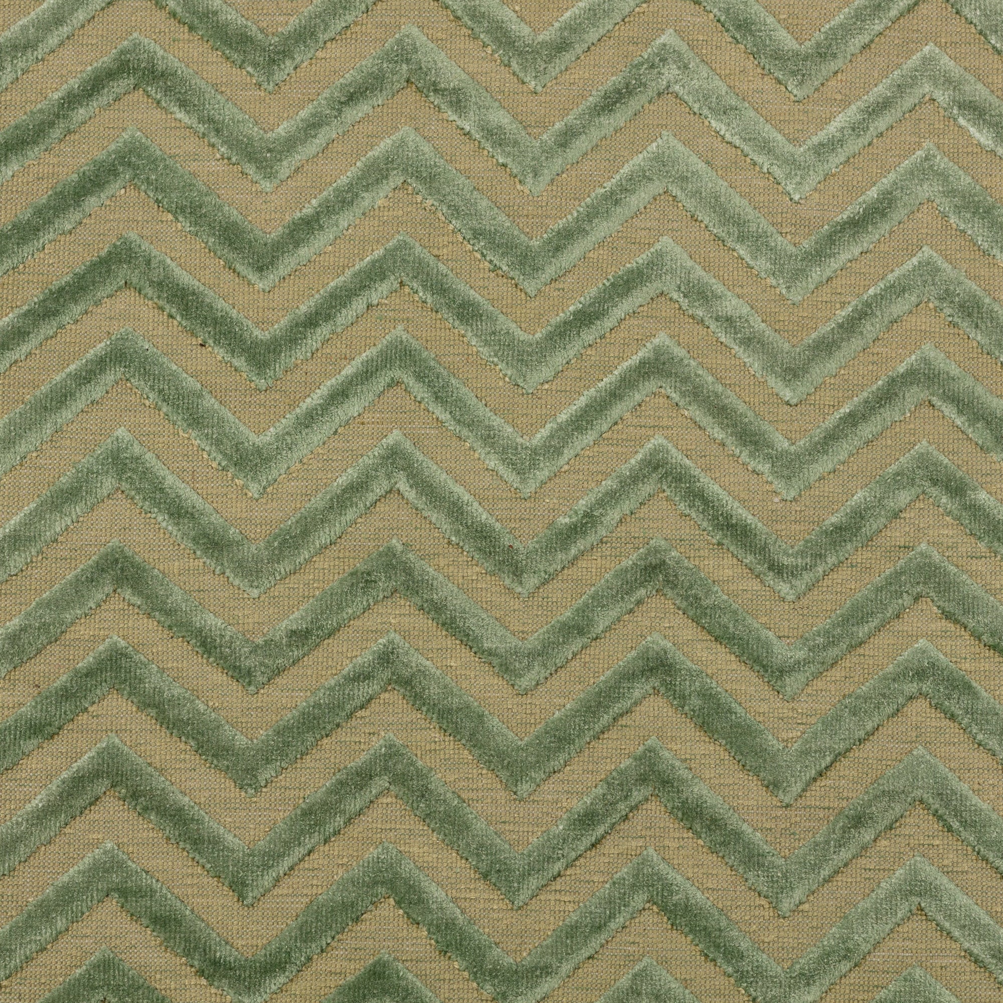 Detail of the Penta Chevron Rug in Pale Jade a light green chevron pattern on a lime green  field with a wide solid border. 
