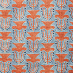 Fabric swatch with a stamped painted floral motif in red and cobalt on a medium blue background