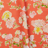 Folded linen swatch with a pattern of large-scale line-drawn flowers in gray ink with red, pink and yellow watercolors, on a red background.