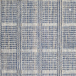 Wool broadloom carpet swatch in a plaid print in shades of navy, tan and cream.