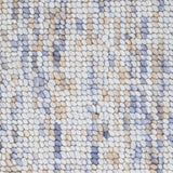 High-pile wool broadloom carpet swatch in a mottled white, brown and blue colorway.