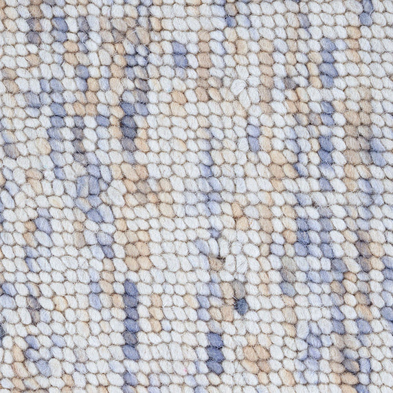High-pile wool broadloom carpet swatch in a mottled white, brown and blue colorway.