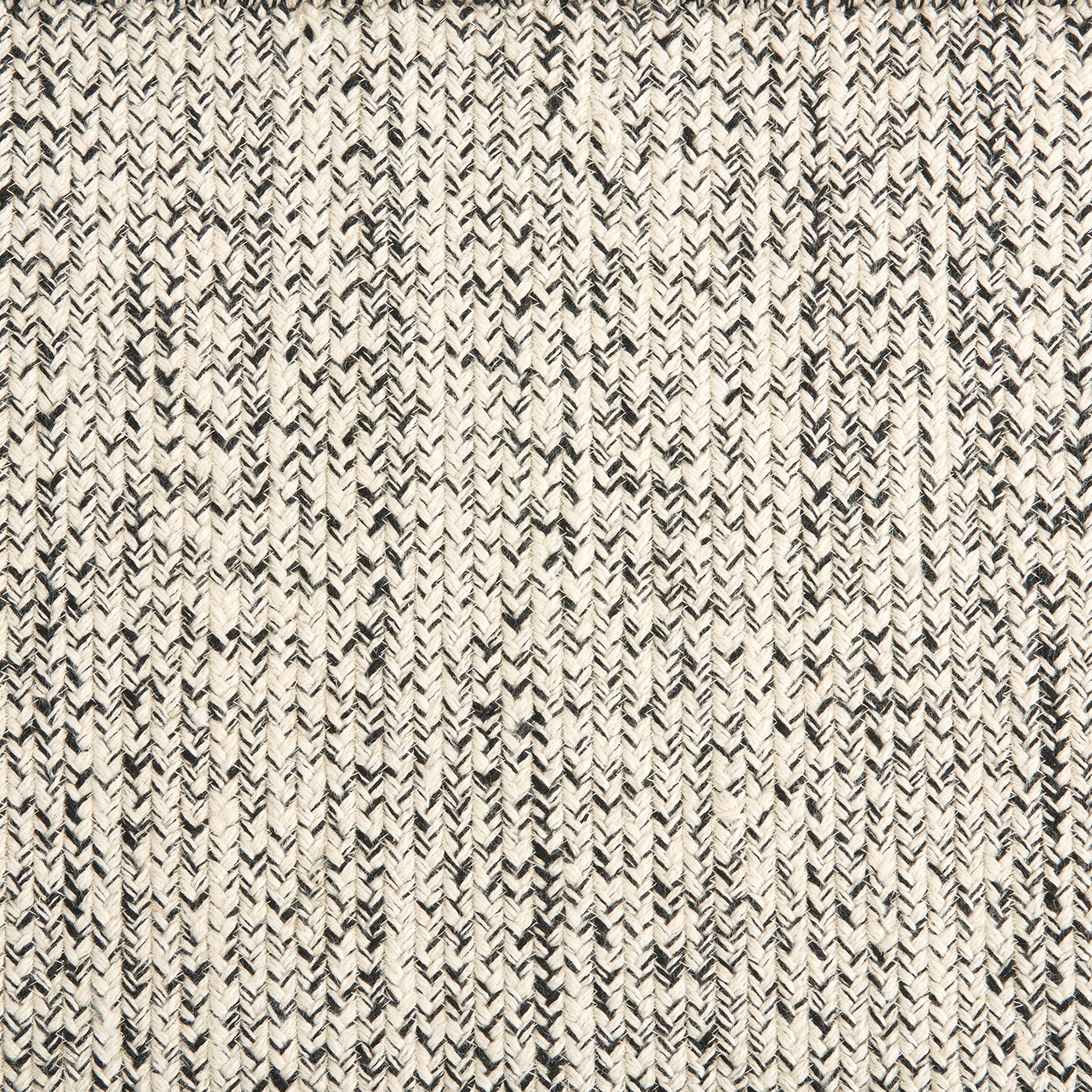 Outdoor broadloom carpet swatch in a chunky ribbed weave in mottled cream and charcoal.