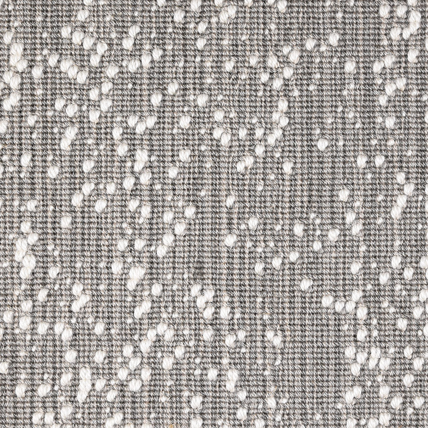 Wool broadloom carpet swatch in an irregular looped weave in charcoal with white accents.