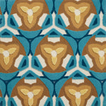 Detail of Gigi Rug featuring a geometric floral motif with a mix of cut pile and linear loops in tan, yellow, ivory and shades of blue