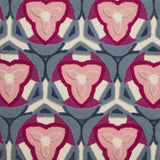 Detail of Gigi Rug featuring a geometric floral motif with a mix of cut pile and linear loops in periwinkle, ivory and shades of pink