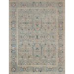 Large rectangular rug in a repeating geometric print with a floral border in shades of blue-gray, rust and navy.
