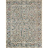 Large rectangular rug in a repeating geometric print with a floral border in shades of blue-gray, rust and navy.