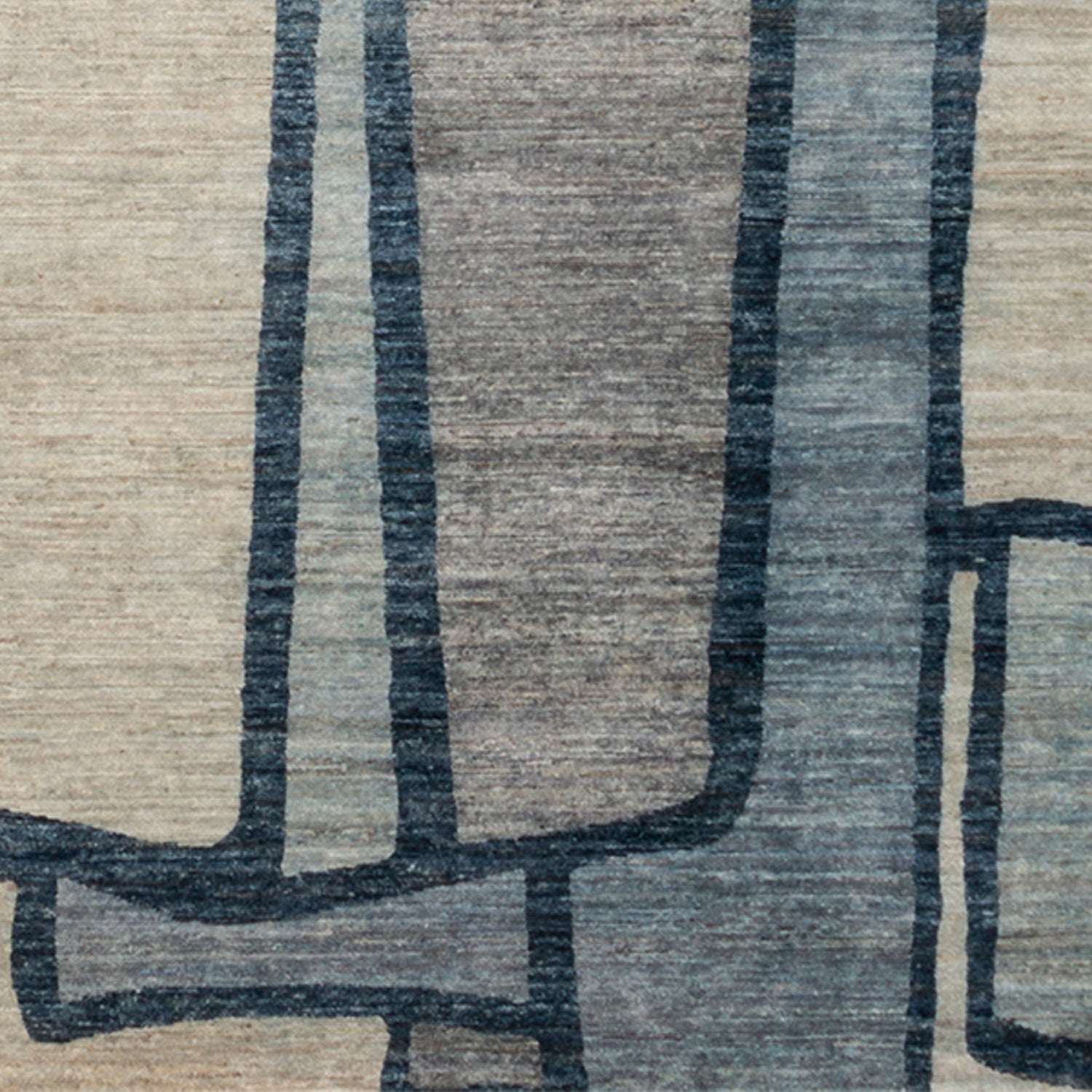 Woven rug swatch in a large-scale abstract pattern of overlapping square shapes in shades of navy, tan and brown.