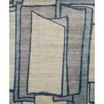 Rectangular rug in a large-scale abstract pattern of overlapping square shapes in shades of navy, tan and brown.