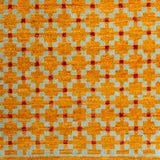 Woven rug swatch in a large-scale grid pattern featuring squares of mustard, light blue and red.