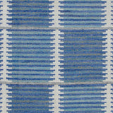 Woven rug swatch in a stripe motif broken by rows of rectangular shapes in white on a blue and green field.