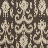 Detail of a woven rug with a cream ikat fleur de lis pattern on a black field.