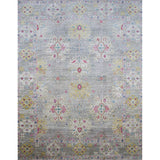 Large rectangular rug in an abstract floral pattern with a repeating floral border print in shades of pink, yellow and red on a mottled gray field.