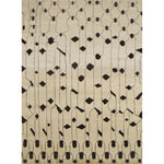 Rectangular high-pile woven rug in an abstract "lantern" line pattern in black on a tan field.