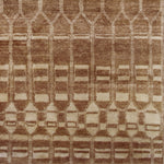 Woven high-pile rug swatch in an elongated linear honeycomb print in tan on a cream field.