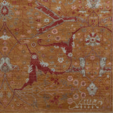 Woven rug swatch in a dense floral print in shades of red, pink and blue-gray on an orange field.