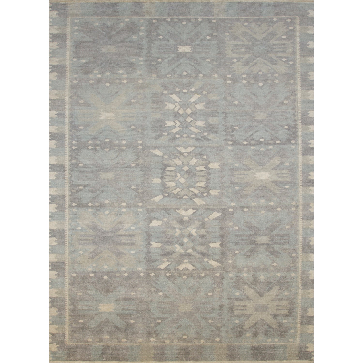 Large rectangular rug in a repeating abstract geometric pattern with a border of jagged geometric shapes, all in shades of gray.