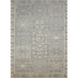 Large rectangular rug in a repeating abstract geometric pattern with a border of jagged geometric shapes, all in shades of gray.