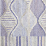 Woven rug swatch with an abstract curvolinear pattern and striped borders in shades of purple and cream.