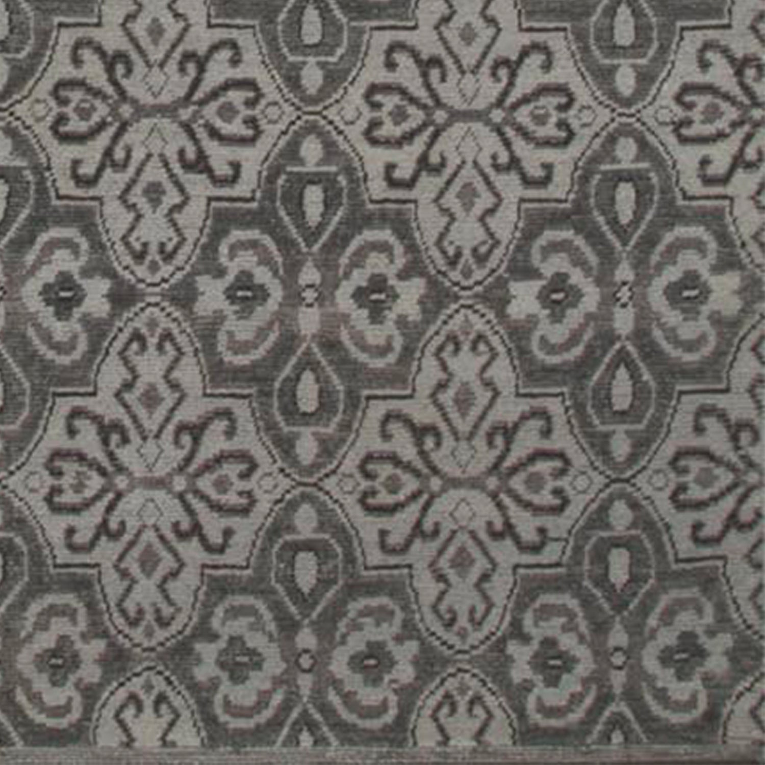Woven rug swatch in a repeating floral paisley in shades of gray.