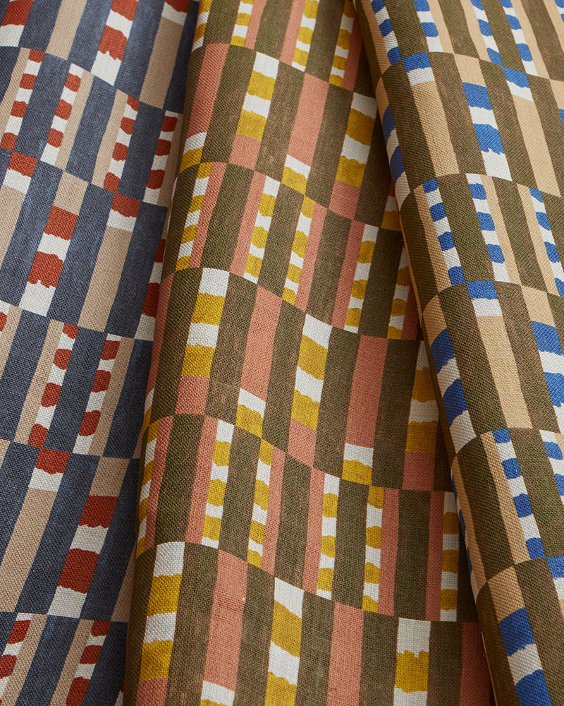 Stack of three folded swatches in a tiled stripe pattern in Carnelian, Jonquil and Cobalt