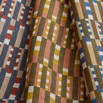 Stack of three folded swatches in a tiled stripe pattern in Carnelian, Jonquil and Cobalt