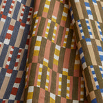 Stack of three folded swatches in a tiled stripe pattern in Carnelian, Jonquil and Cobalt